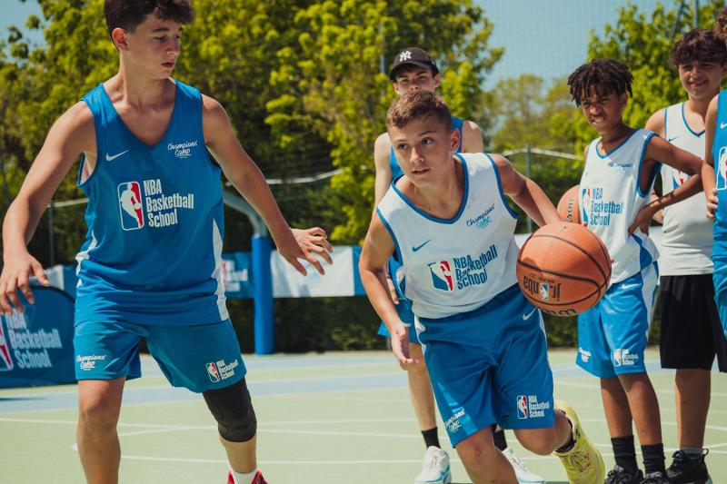 I giocatori del campo estivo basket corrono lungo il campo durante gli allenamenti