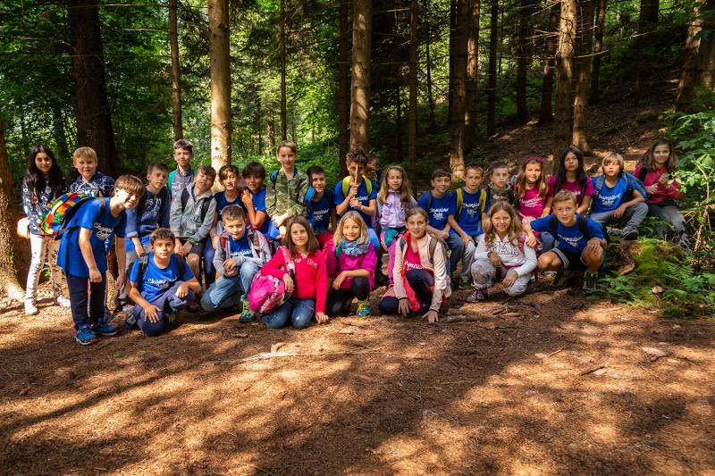 I bambini del campo estivo arrampicata scattano una foto di gruppo nel bosco