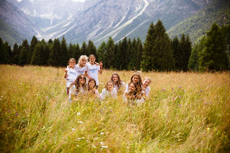 Al campo estivo in montagna per ragazzi alcune ragazze sono immerse in mezzo a delle piantagioni alte e verdi in montagna