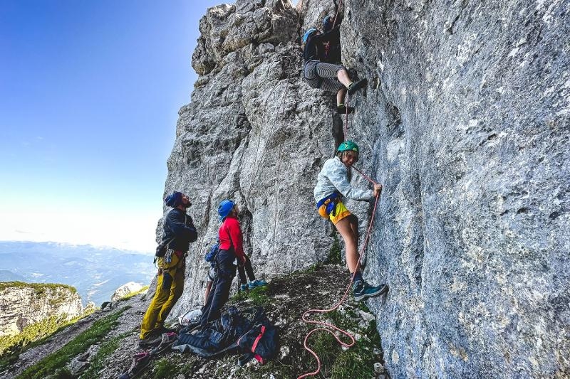 I partecipanti del campo estivo arrampicata scalano una parete rocciosa