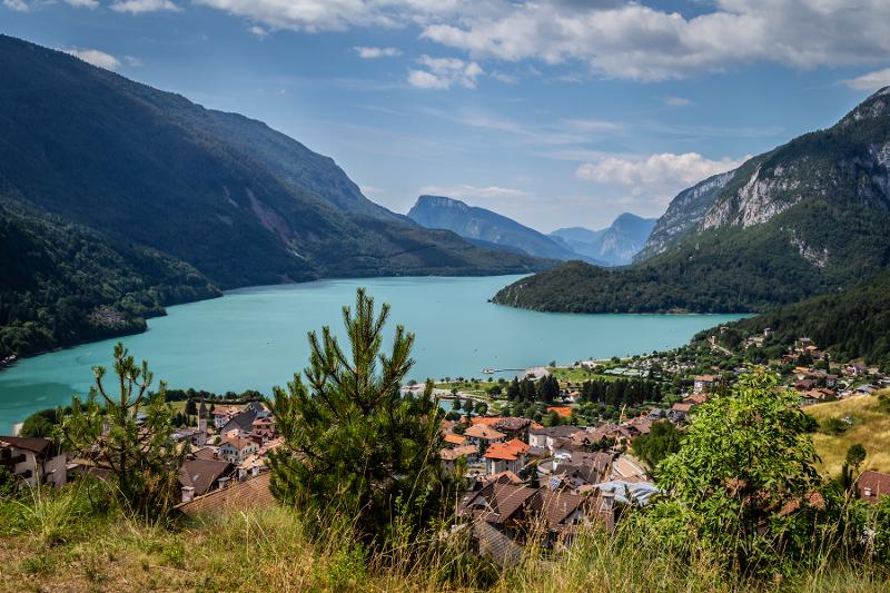 Al campo estivo tennis si vede un panorama stupendo che raffigura un lago, le montagne e alcune case colorate