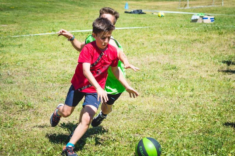 Al campo estivo Molise due bambini di squadre opposte inseguono il pallone sul prato 
