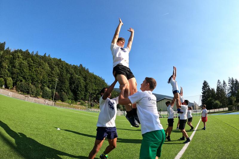 I giocatori del campo estivo rugby si allenano sulle rimesse da bordo campo lanciando in aria i loro compagni