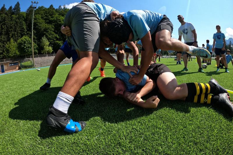 I giocatori del campo estivo rugby si buttano nella mischia