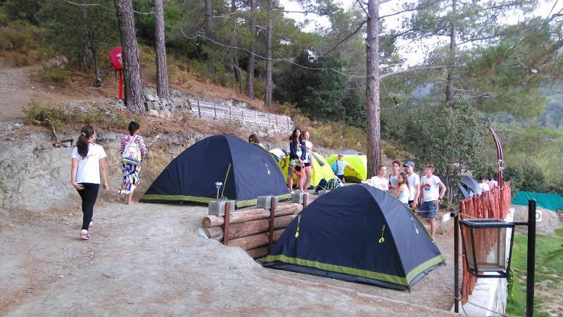 Al campo estivo internazionale a Cipro ci sono i ragazzi nella natura che stanno sistemando le tende per la notte