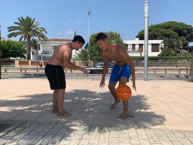 Momenti di svago al campo estivo internazionale in Spagna Al campo estivo internazionale in Spagna due ragazzi stanno giocando a basket insieme
