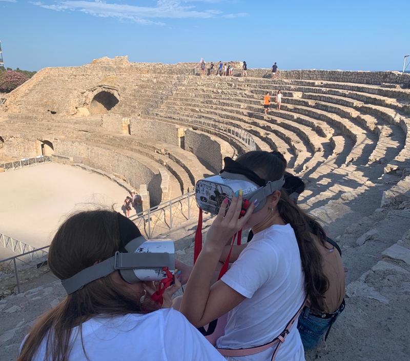 Visita all'anfiteatro con la realtà aumentata al campo estivo internazionale in Spagna Al campo estivo internazionale in Spagna due ragazze stanno usando la realtà aumentata per la visita all'anfiteatro