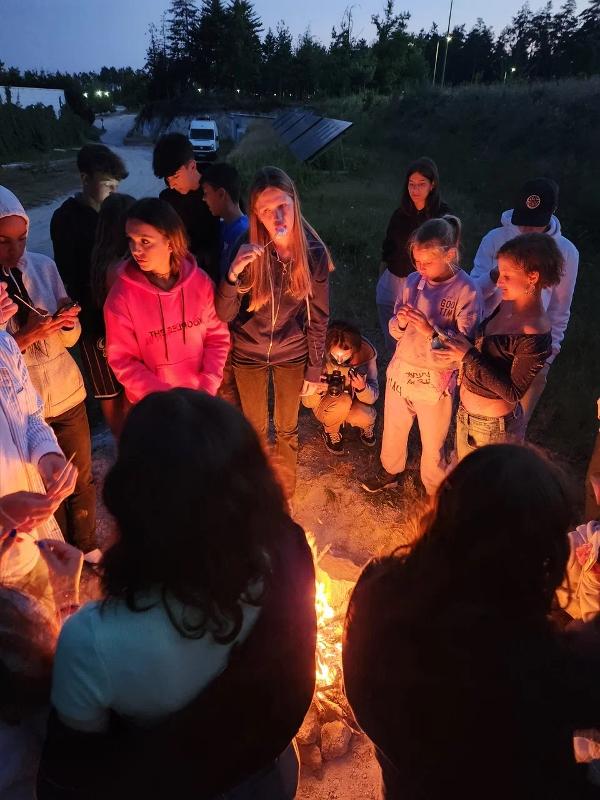 Diversi bambini sono attorno ad un falò e mangiano delle caramelle al campo estivo inglese mare