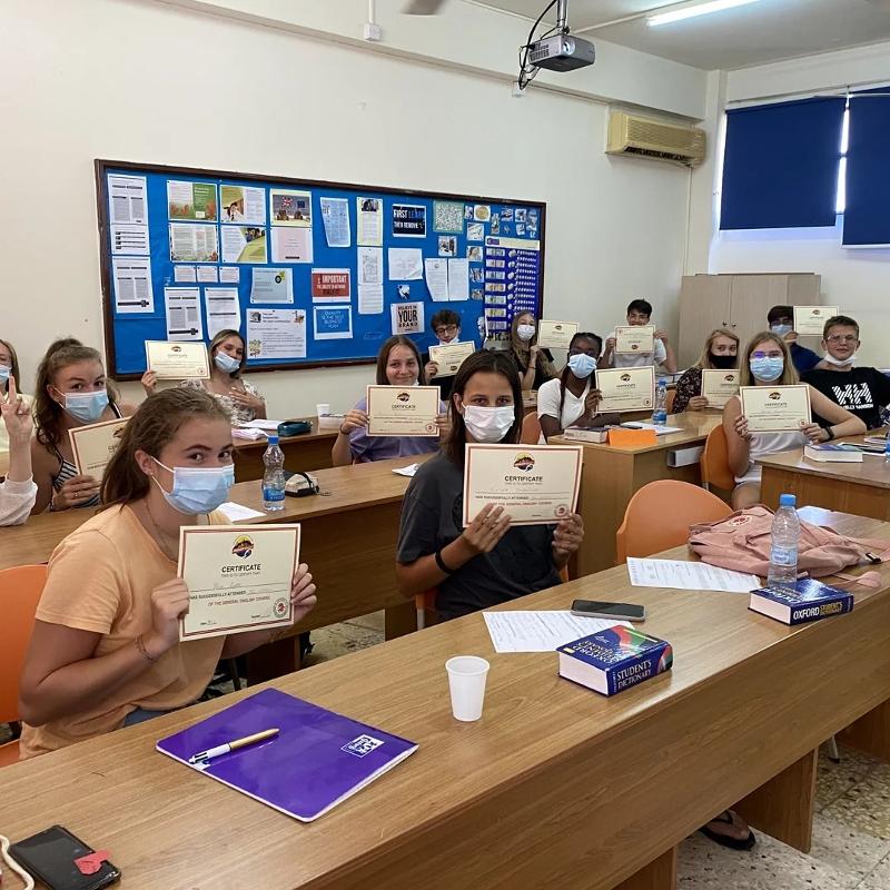 Al campo estivo internazionale a Cipro i ragazzi della classe stanno mostrando il loro certificato di fine corso 