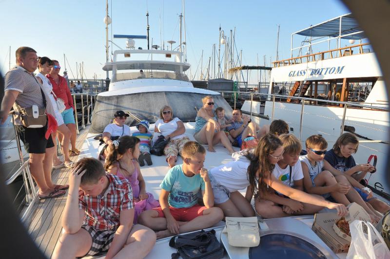Al campo estivo internazionale a Cipro i bambini stanno facendo una cena in barca 