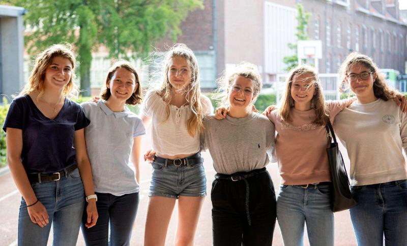 Sei ragazze posano insieme in giro per la città al soggiorno linguistico in olandese