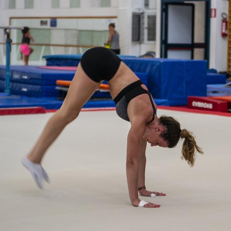 Al campo estivo ginnastica artistica una ragazza sta per eseguire una verticale sul tappeto