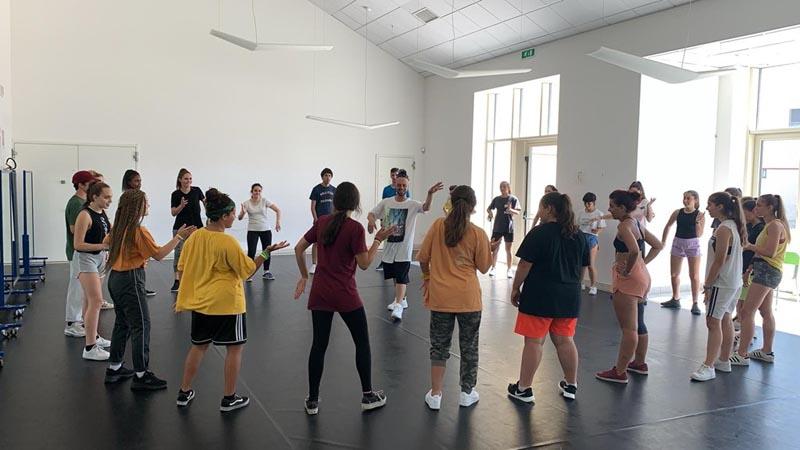 I ragazzi del campo estivo danza sono messi in cerchio attorno al maestro