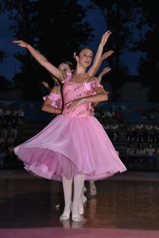 Alcune ragazze con dei vestiti rosa eseguono un balletto di sera al campo estivo danza