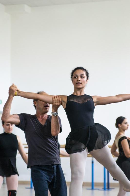 Il maestro aiuta la ragazza a saltare in aria eseguendo una mossa al campo estivo danza 