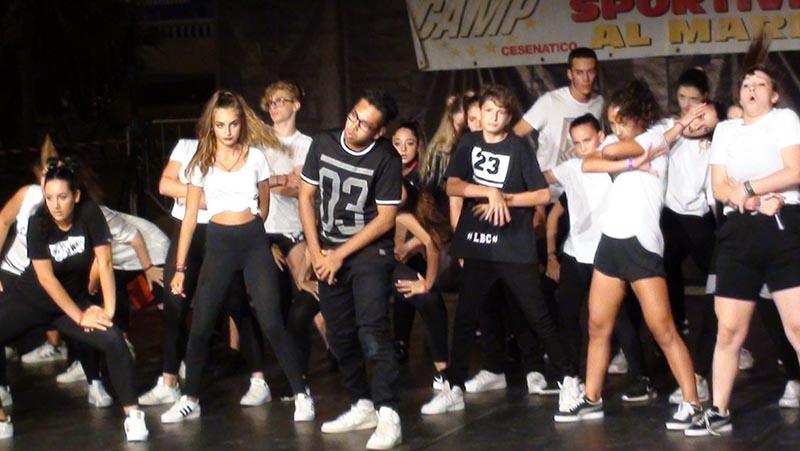Al campo estivo danza i ragazzi e le ragazze sono sul palco e eseguono delle mosse