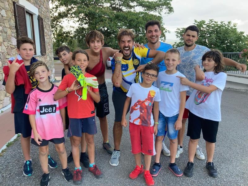 Maestri e bambini sorridono insieme al campo estivo musica
