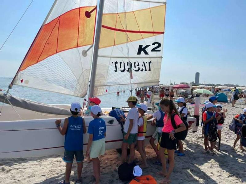 Al campo estivo Liguria i bambini sono in spiaggia accanto a una barca