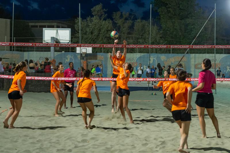 Al campo estivo pallavolo i ragazzi stanno facendo una partita in spiaggia di sera