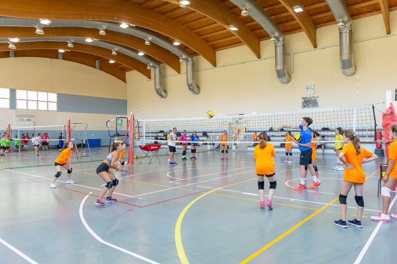 Al campo estivo pallavolo i partecipanti si stanno allenando in palestra 