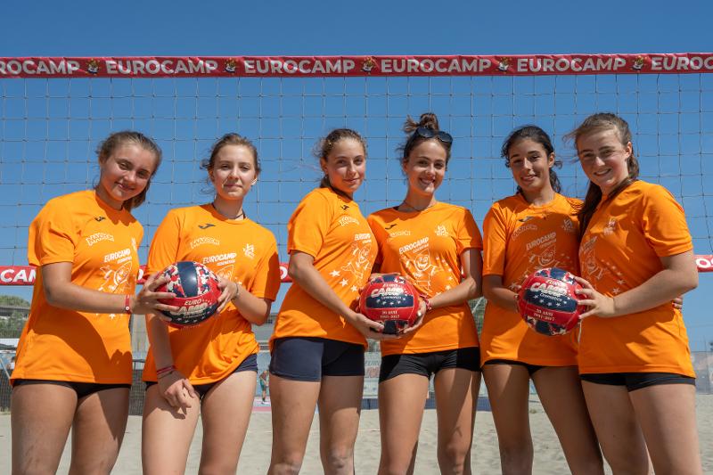 Al campo estivo pallavolo le ragazze si stanno facendo una foto di gruppo in campo