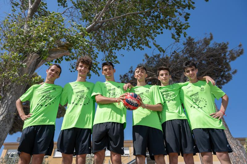 Al campo estivo pallavolo i ragazzi si stanno facendo una foto di gruppo con le magliette del camp
