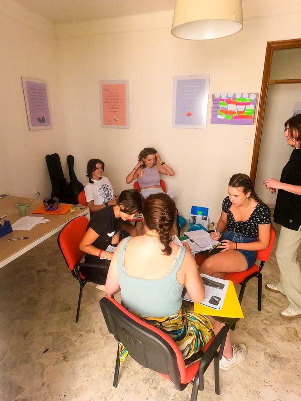 Al soggiorno linguistico italiano ad Alberobello i ragazzi sono seduti insieme e stanno facendo un attività 