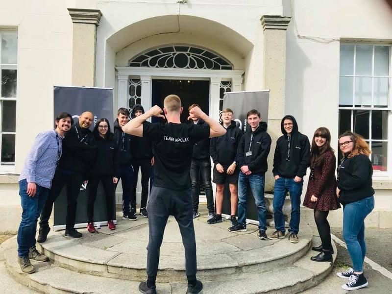 C'è un gruppo di ragazzi che posano per una foto e c'è un ragazzo girato di spalle che indica sull maglietta "Team Apollo" durante il soggiorno linguistico inglese a Dublino