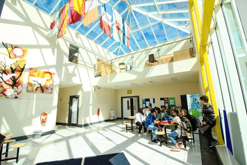 Ragazzi seduti nella hall dell'istituto del soggiorno linguistico dopo le lezioni di inglese