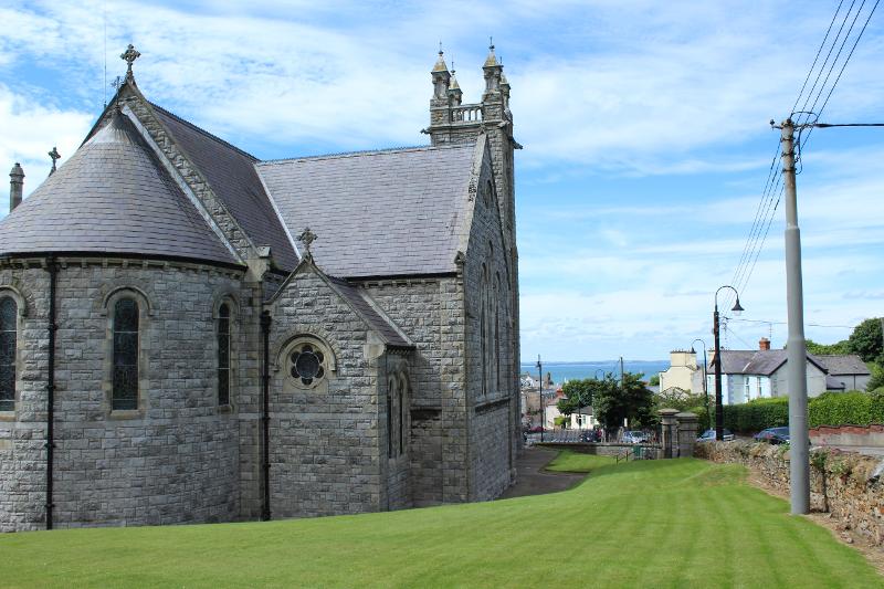 Vista di un'antica chiesa circondata da mare e verde durante il soggiorno linguistico Dublino