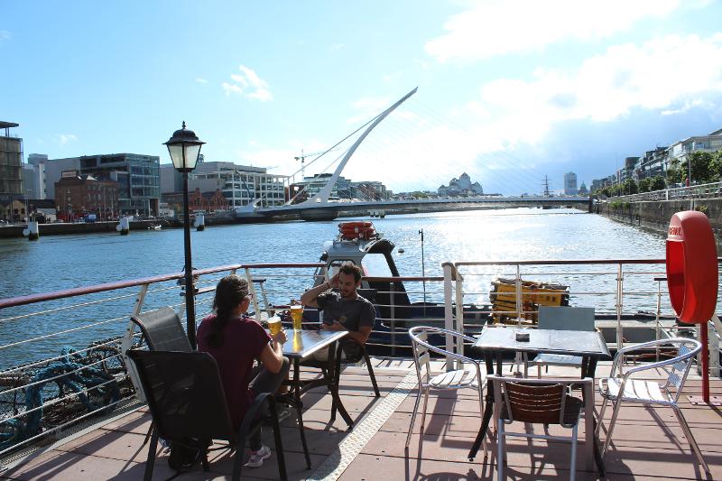 Delle persone si bevono una birra con vista sul Liffey durante il soggiorno linguistico Dublino