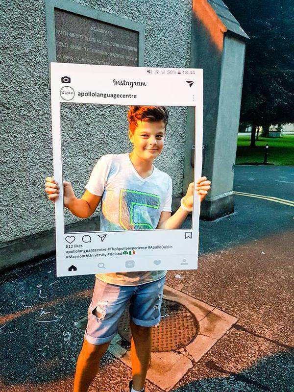 Vi è un bambino che posa per una foto con il riquadro di instagram al soggiorno linguistico Dublino