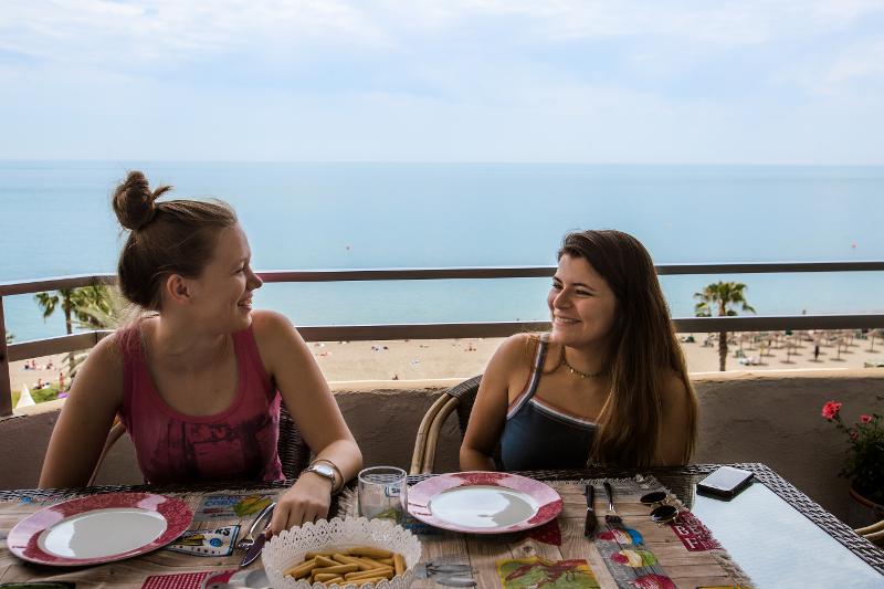 Una studentessa del soggiorno linguistico spagnolo ride felicemente con la sua famiglia ospitante