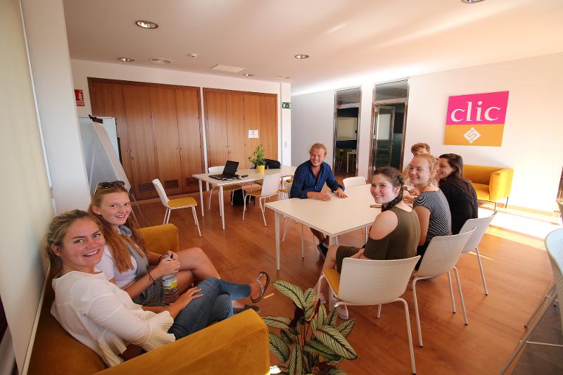 Al soggiorno linguistico spagnolo gli studenti siedono insieme su sedie e divano