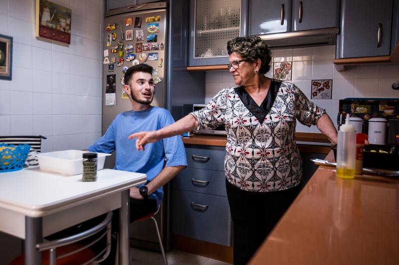 Un ragazzo siede a tavola mentre la signora della casa cucina, opzione del soggiorno linguistico spagnolo