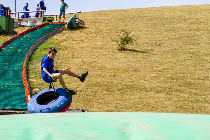 Un ragazzo scende da uno scivolo con un gommone e fa un salto nel verde al campo estivo Molise
