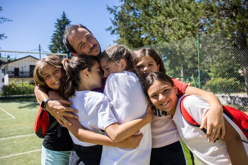 Alcune ragazze abbracciano l'istruttore al campo estivo Campania