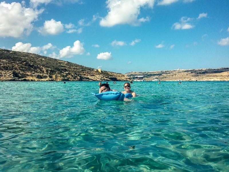Al soggiorno linguistico estivo in inglese a Malta due ragazze stanno nuotando nel mare cristallino 