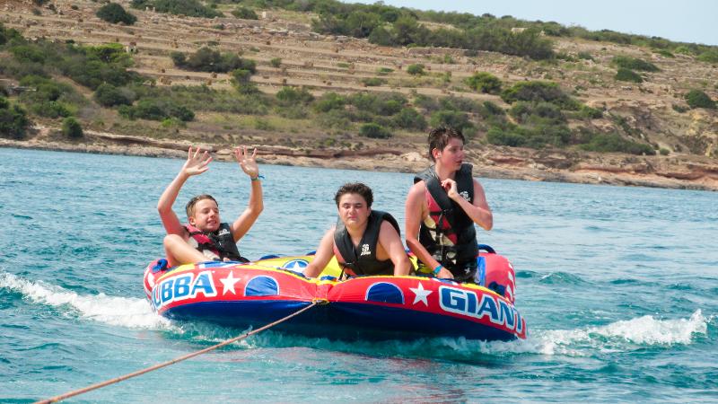 Al soggiorno linguistico estivo in inglese a Malta tre ragazzi stanno facendo un attività in mare 