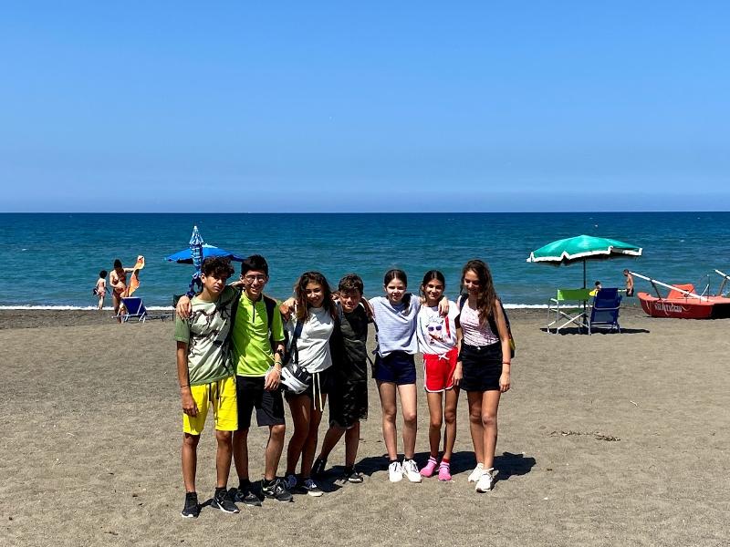 Al campo estivo Veneto alcuni ragazzi abbracciati scattano una foto insieme in spiaggia