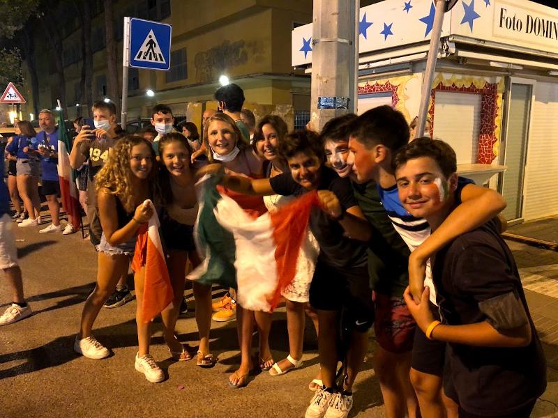 I ragazzi dei campi estivi per ragazzi in Italia sventolano la bandiera italiana per strada per festeggiare