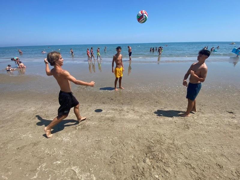 Ai viaggi organizzati Puglia tre ragazzi giocano a palla in spiaggia