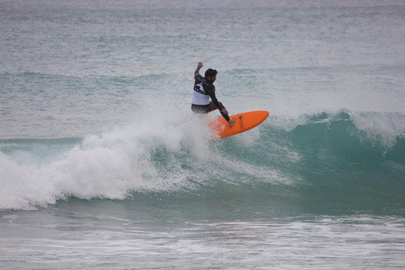 Un ragazzo del campo estivo surf esegue un'acrobazia sulla cresta dell'onda