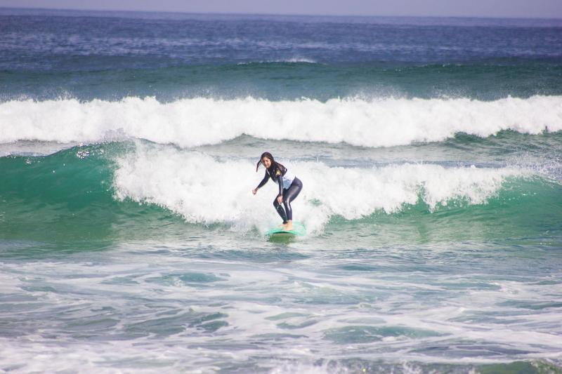 Una ragazza del campo estivo surf cavalca un'onda con controllo e stile