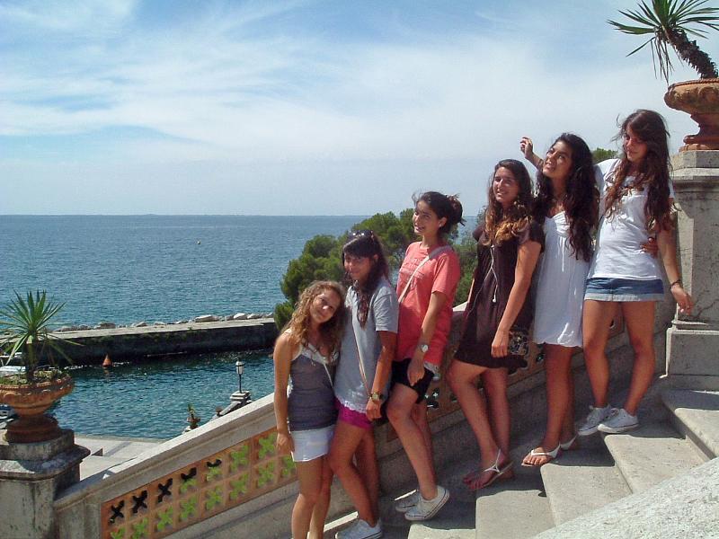Un gruppo di ragazze fa una foto su degli scalini davanti al mare ai viaggi organizzati in Friuli Venezia Giulia