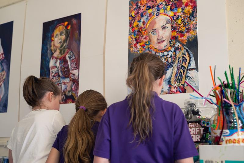 Tre bambine al soggiorno in lingua inglese nel cuore della Scozia mentre ammirano delle opere d'arte appese al muro