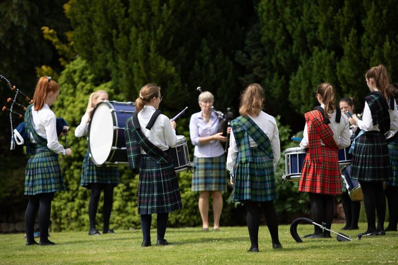 Un gruppo di ragazze vestite con abiti tipici scozzesi suonano la cornamusa alle vacanze studio Edimburgo