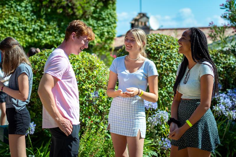 Al soggiorno linguistico francese tre ragazzi stanno avendo una conversazione felice