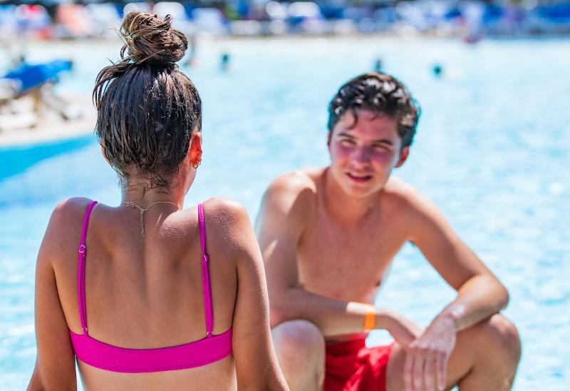 Al soggiorno linguistico francese ci sono un ragazzo e una ragazza che stanno parlando 