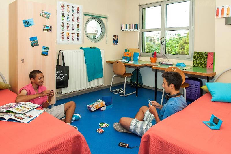 Al soggiorno linguistico francese due ragazzi sono in camera e stanno giocando a carte 